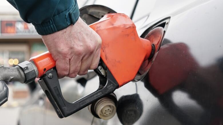 A man pumps gas into a car.