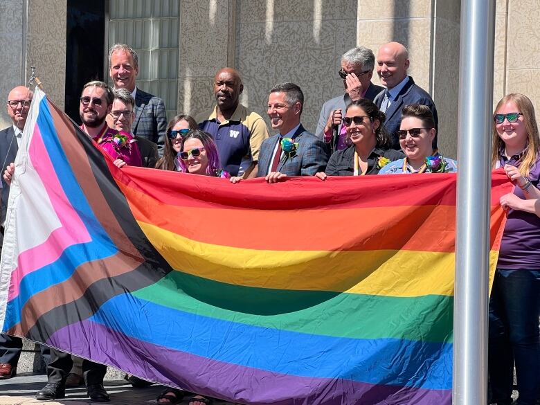 People hold a pride flag.