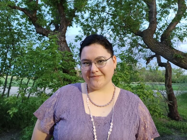 Ell Bird poses in a stand of trees. They work with queer youth in Moose Jaw, Sask.