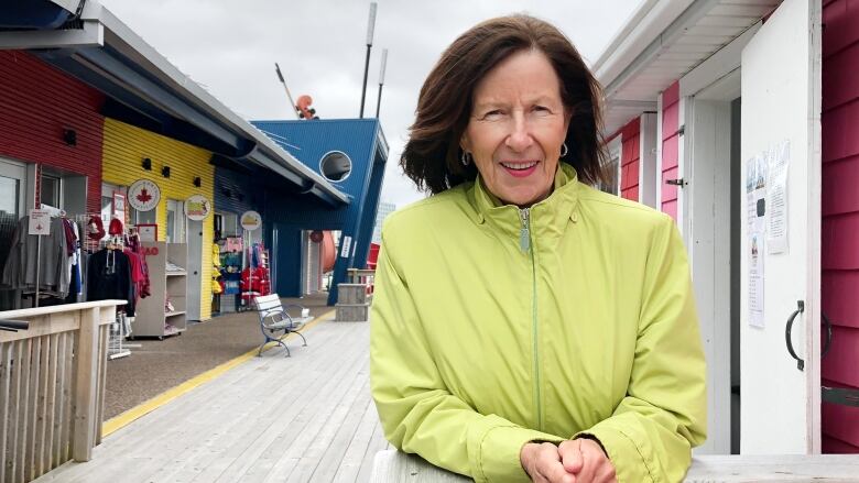 A woman looks at the camera while standing in front of retail kiosks on Sydney's downtown waterfront.