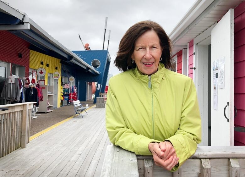 A woman looks at the camera while standing in front of retail kiosks on Sydney's downtown waterfront.