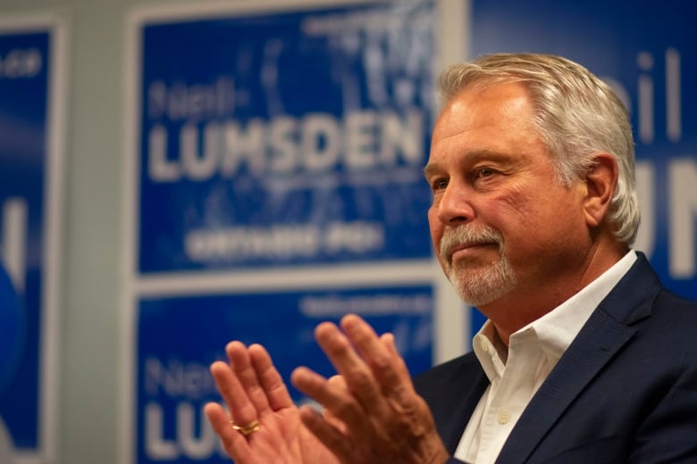 A man in front of campaign signs. 