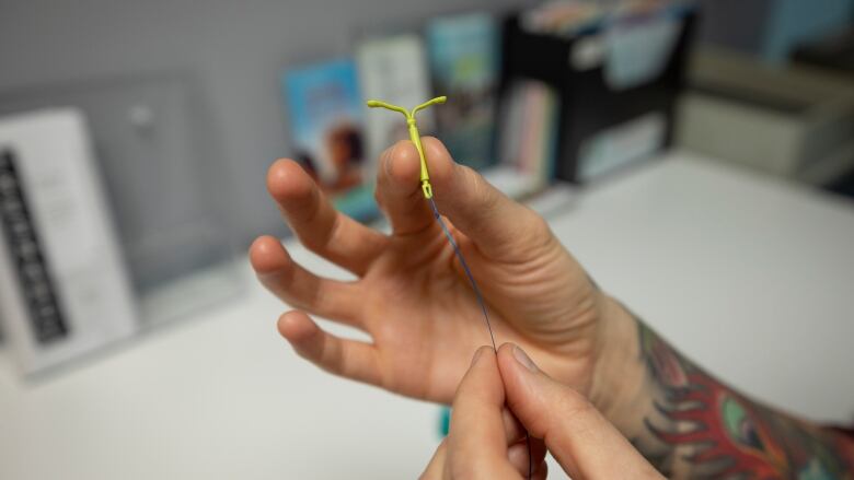 Demonstration of how to insert an intrauterine device (IUD) into a uterus model.