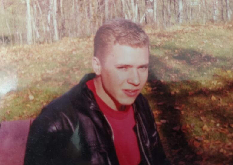 A teenage boy in a leather jacket.