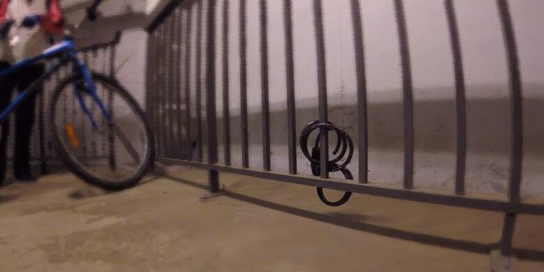 A bike rack with a cut bike lock and bicycle in the background.