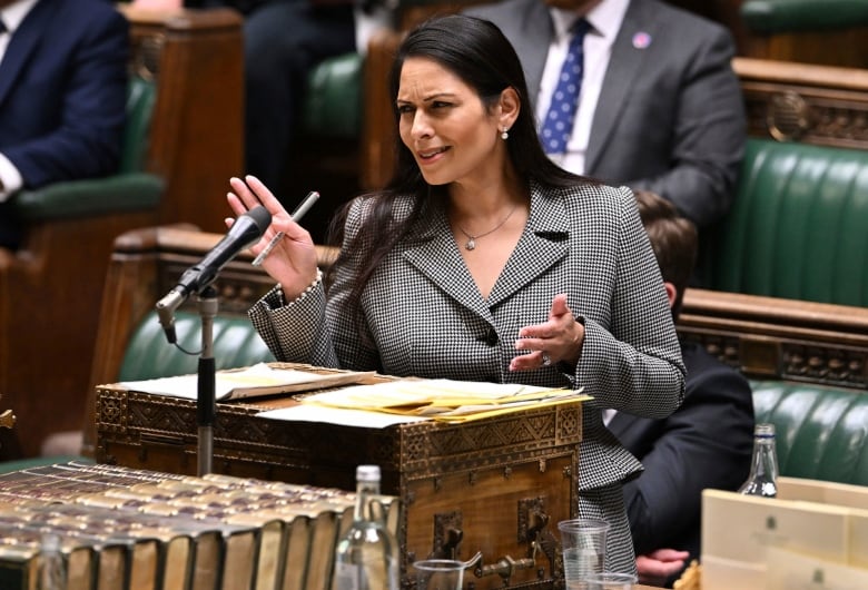 A woman speaks at a podium in the British Parliament. 