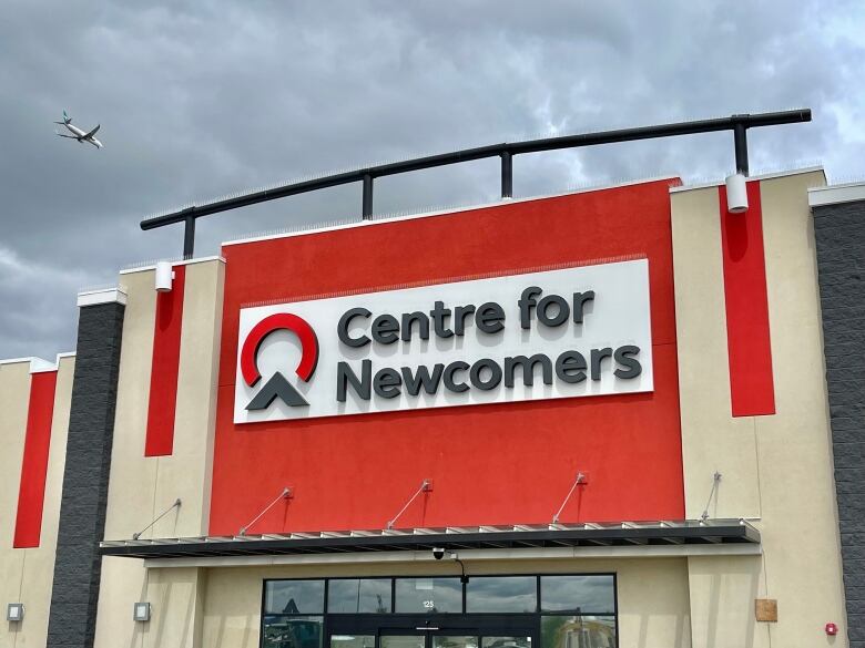 A building with a red sign that reads centre for newcomers.