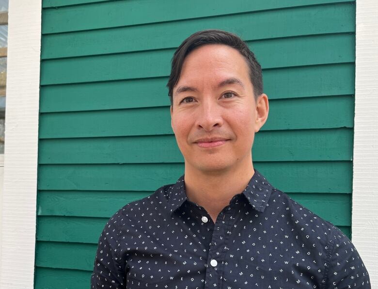 A young man is smiling into the camera.