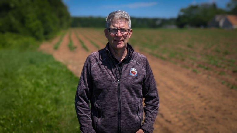 Greg Donald standing in a potato field.