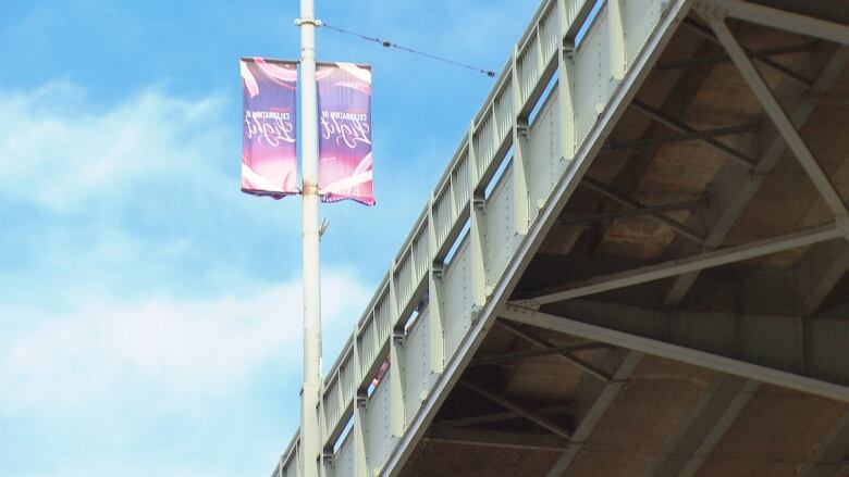 A large bridge with a sign alongside it.