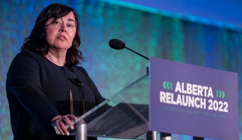 A woman stands at a podium to give a speech.