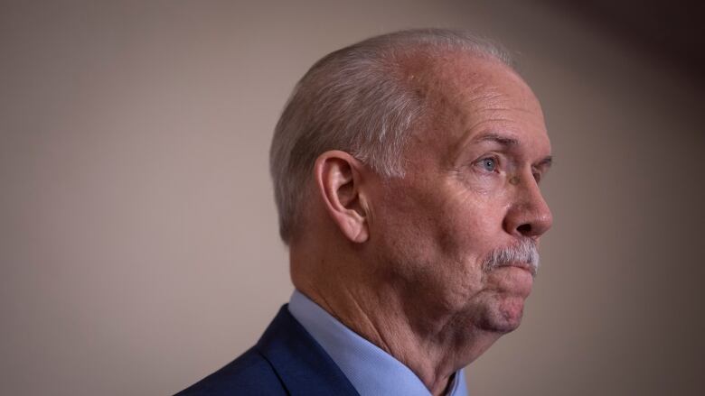 John Horgan purses his lips. He is a white man with a white moustache.