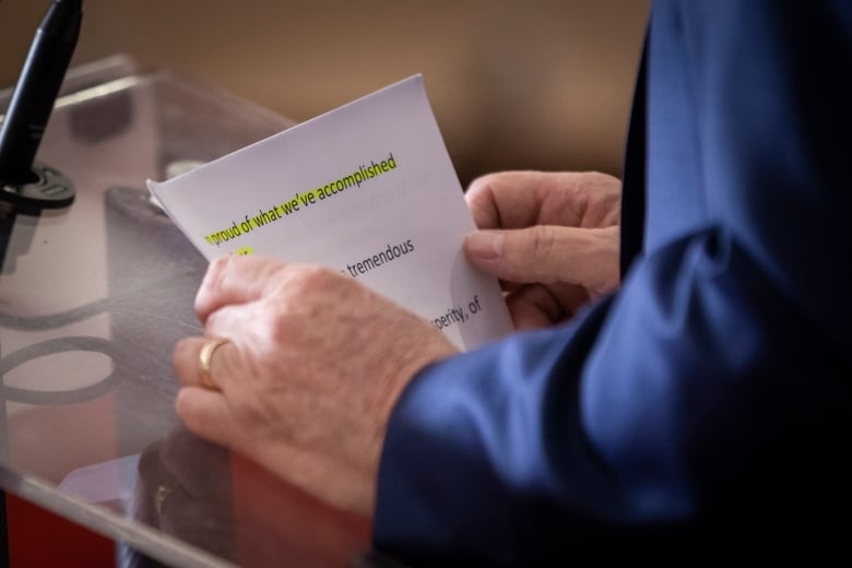 A man holds notes, with a line highlighted at the top saying 'I'm proud of what we've accomplished'.