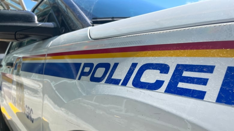 close up shot of the side of a police car that has yellow and red stripes with the word police on the side