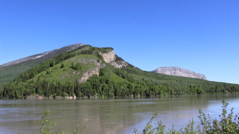 A mountain rises above a river.