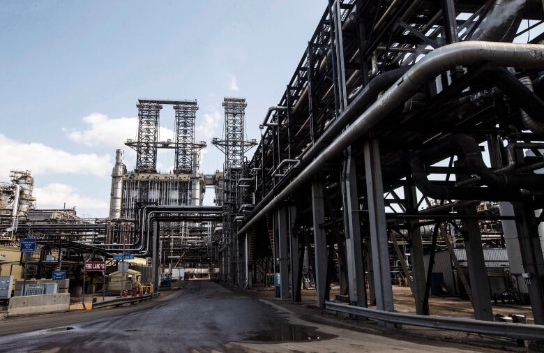 An industrial complex of pipes and a road make up an upgrader at Suncor's oil sands base plant in Fort McMurray Alta.