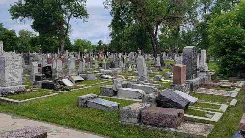 Gravestones are seen tipped over.