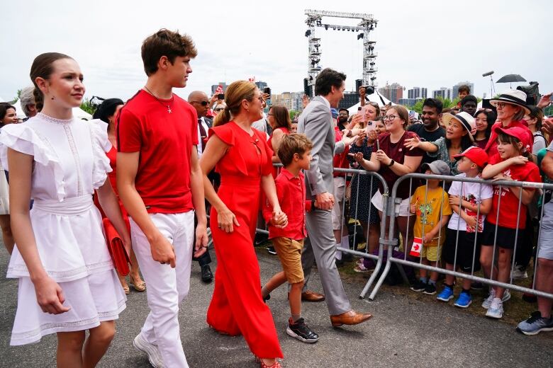 People walk and shake hands with a crowd.