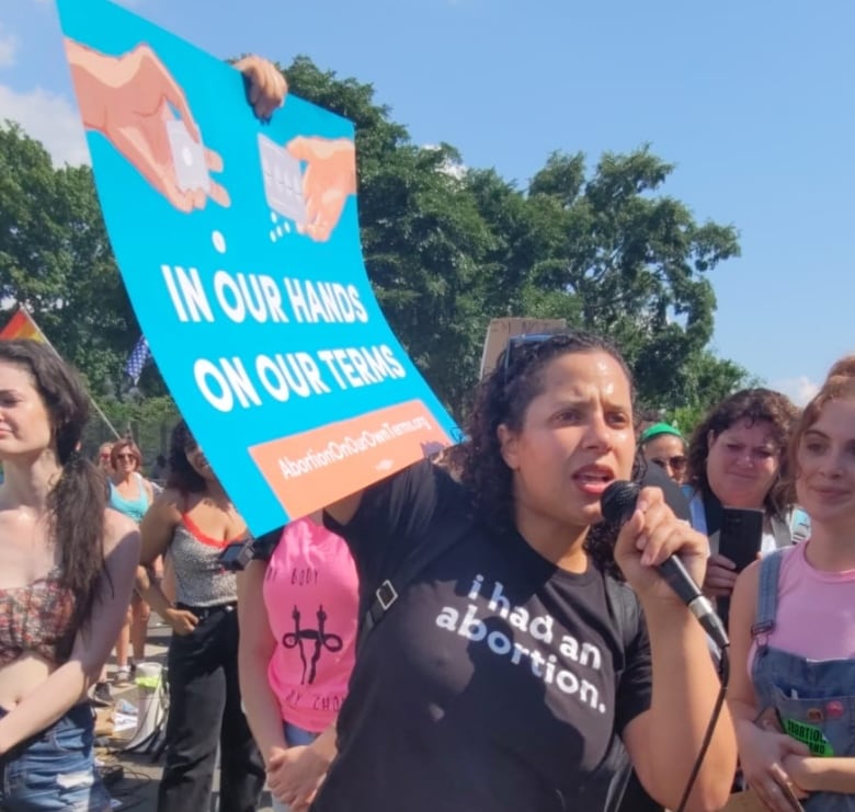 A woman wearing a black t-shirt, with the message 