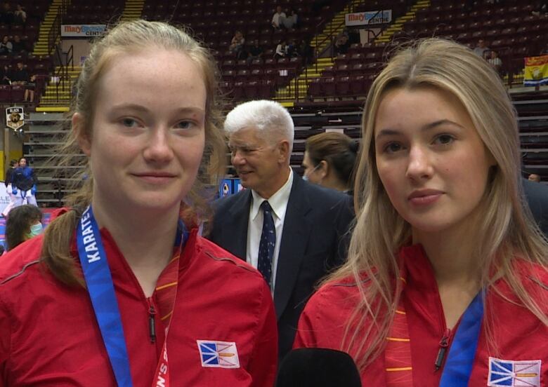 Two teenaged girls look into the camera.