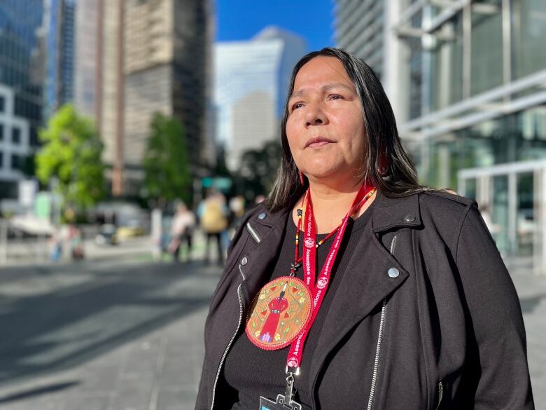 Judy Wilson looks austere as she stands on a street.