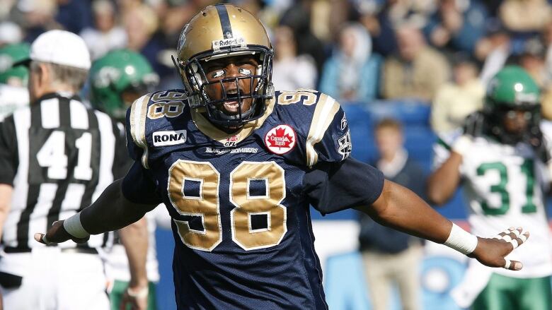 A football player spreads his arms wide and cheers.