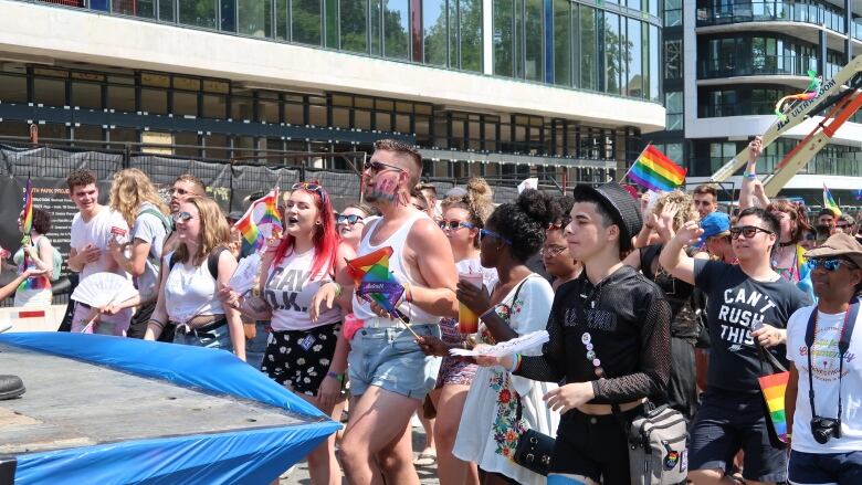 Marchers wave rainbow flags during the 2019 Halifax Pride Parade.