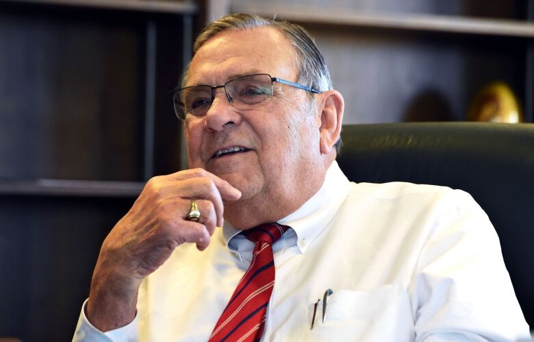 A middle-aged man sits in an office. 