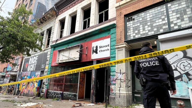 Police tape and an officer are in front of a building with a sign that reads 'Street Church' and artwork of Jesus Christ.