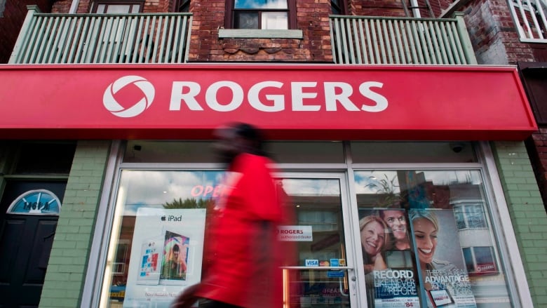 A person walks by a Rogers sign