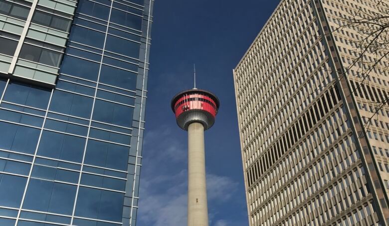 Two office towers appear to dwarf the Calgary Tower (view from ESE) Blue sky bg.