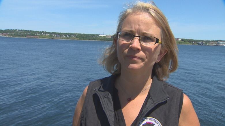 Tonya Wimmer, executive director of the Marine Animal Response Society, is seen standing in front of a large body of water in the Halifax area.