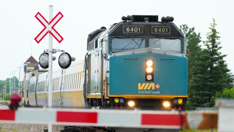 A Via Rail train approaches a crossing. 