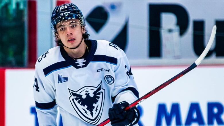 A Cree hockey player in uniform for a Quebec Major Junior Hockey League team, the Sherbrooke Phoenix skates towards the camera.