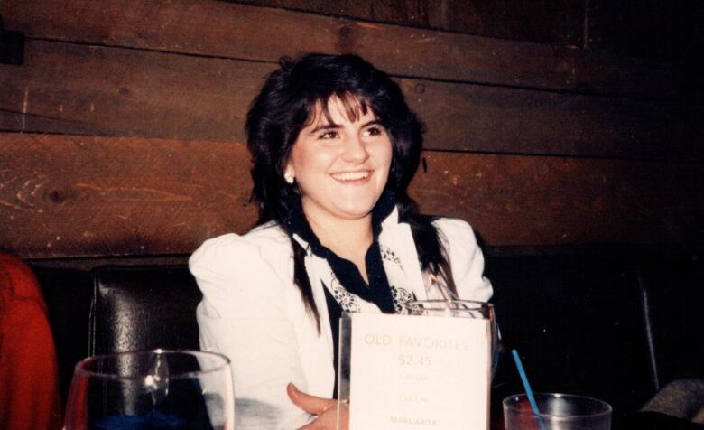 A woman at a table with drinks.