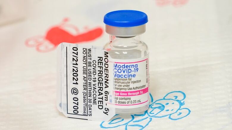 A vial of vaccine on a table.