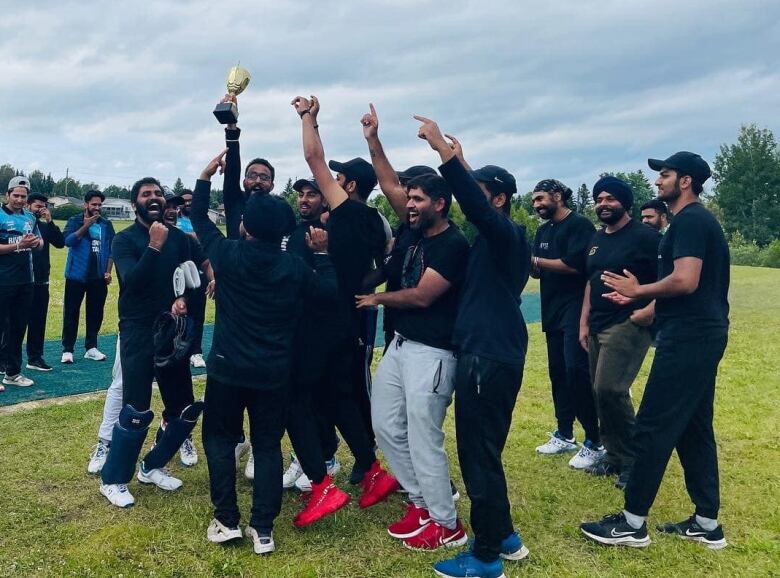 A team cheering with one player holding a trophy in their hands.