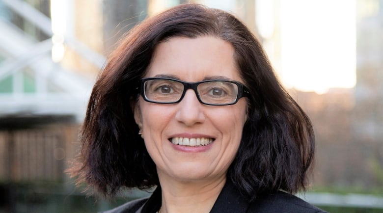 Portrait of woman with dark hair and glasses.