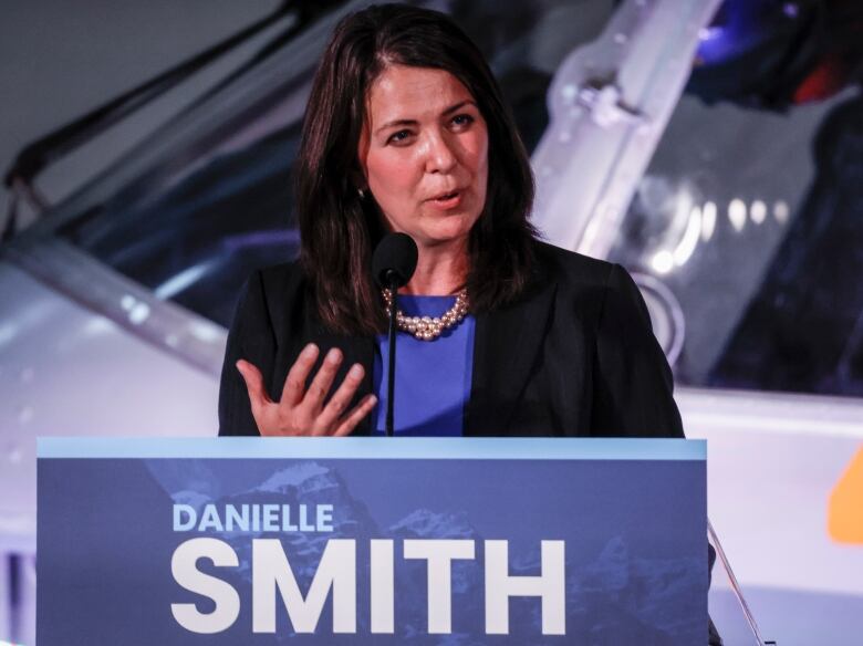 A woman stands at a podium and speaks.