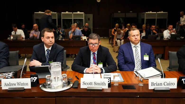 Lawyer Andrew Winton sits alongside witnesses Scott Smith, Hockey Canada President and Chief Operating Officer and Hockey Canada Chief Financial Officer Brian Cairo, as they appear at the standing committee on Canadian Heritage in Ottawa on Wednesday.