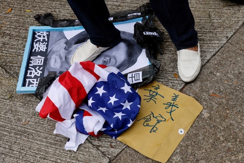 A pro-China supporter steps on a defaced photo of U.S. House of Representatives Speaker Nancy Pelosi during a protest against her visit to Taiwan outside the Consulate General of the United States in Hong Kong on Wednesday, Aug. 3, 2022.