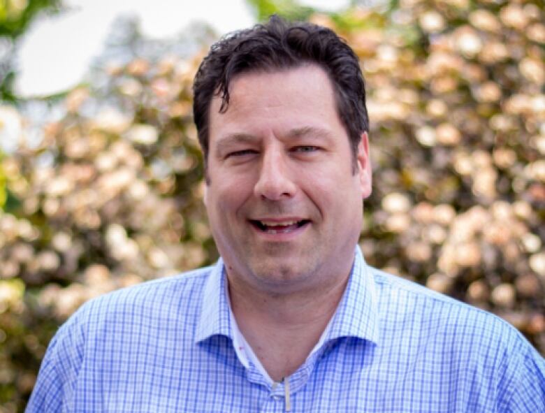 Man in dress shirt poses for portrait.