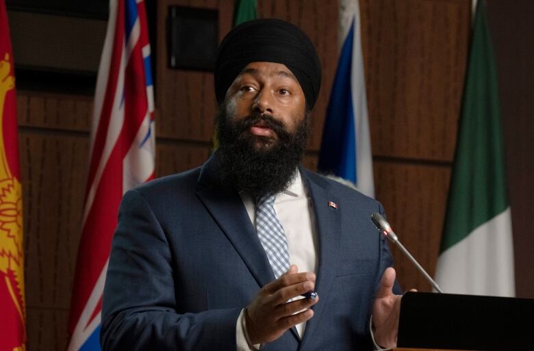 A politician at a podium speaks into the microphone.