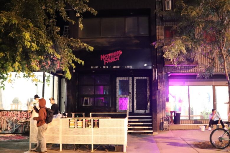 Nighttime photograph of a building exterior on Augusta Street in toronto. The black awning reads 