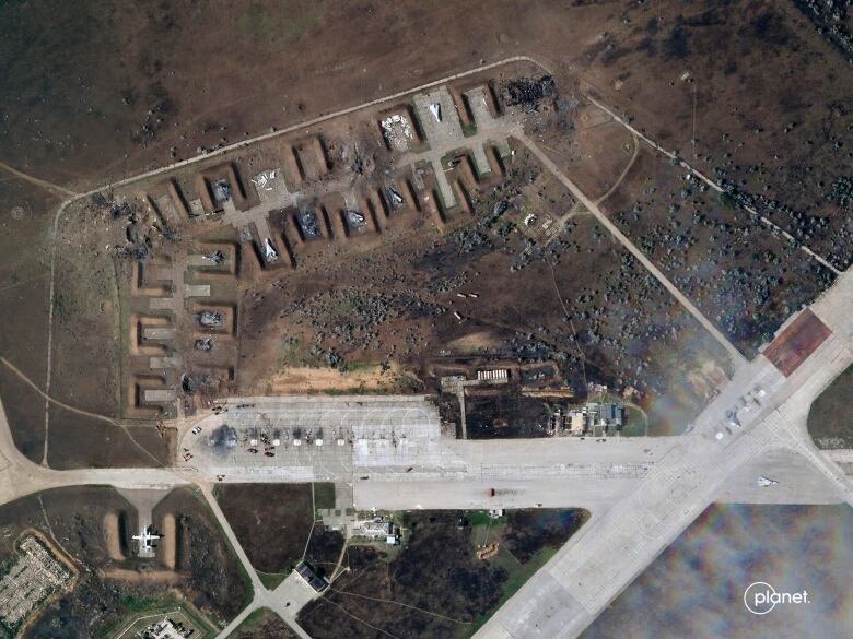 An aerial image showing concrete runways with charred areas of the ground nearby.