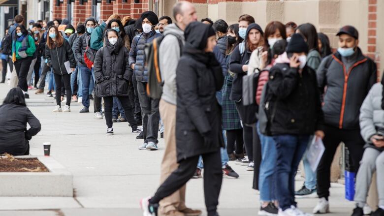 People line up outside a Service Canada office in Toronto on Apr. 26, 2022. Loosening travel restrictions have led to a rise in demand for passports.