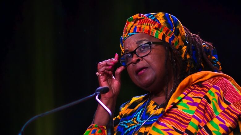 Black woman wearing African print dress at podium