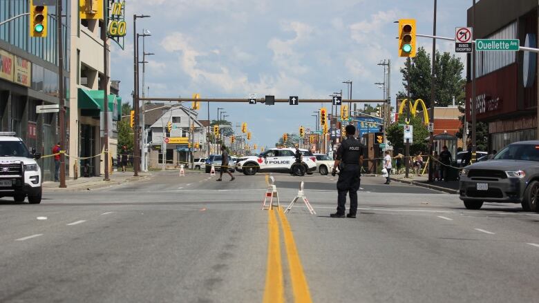 Police cars and officers block a downtown intersection.