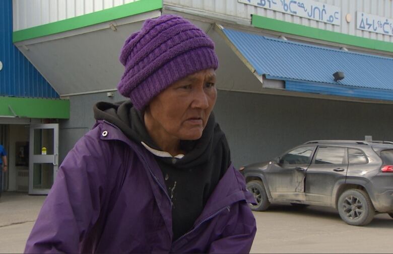 Close up of bewildered woman wearing purple.