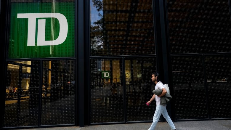 A woman walks in front of a TD Bank building